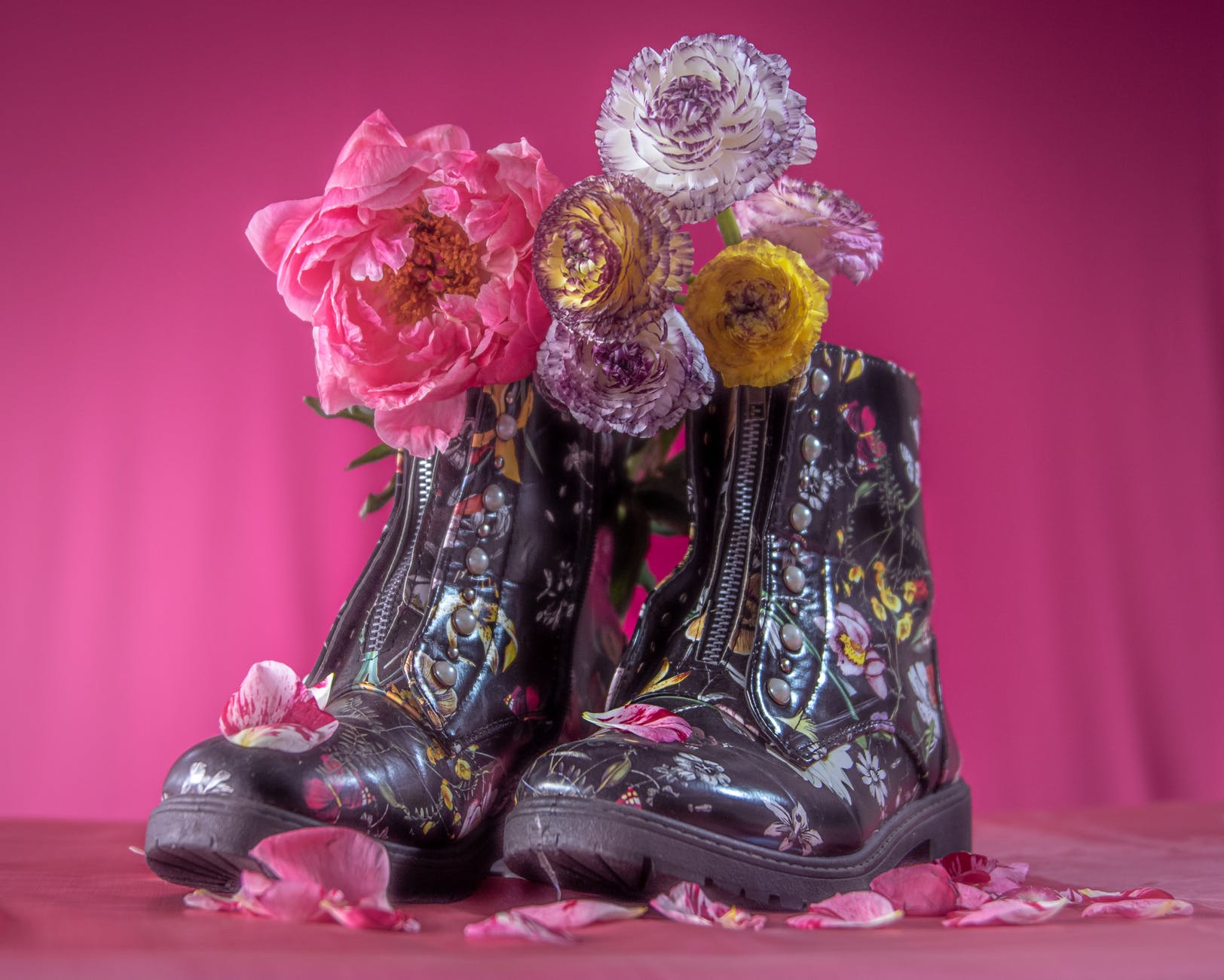 photo of flowers on shoes against pink background